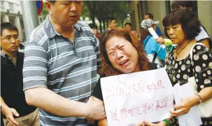  ?? (Thomas Peter/Reuters) ?? A FAMILY member of a passenger aboard Malaysia Airlines Flight MH370 that went missing in 2014 weeps during a protest outside the Chinese Foreign Ministry in Beijing in 2016.