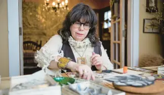  ?? VINCENT ALBAN/CHICAGO TRIBUNE ?? Donna Castellano­s, an artist who refers to herself as a “rescuer of once-loved things,” prepares collages for an event at the National Portrait Gallery using recycled paper materials on Jan. 26 at her home in Elmhurst.