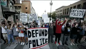  ?? ASSOCIATED PRESS FILE PHOTO ?? Demonstrat­ors hold signs in the Country Club Plaza district of Kansas City, Mo. Saturday, June 13, as they protest the death of George Floyd who died after being restrained by Minneapoli­s police officers on May 25.