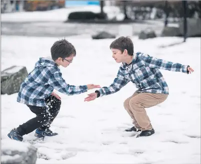  ??  ?? SNOW SCENE: Hugo, nine, left, and Jacob, six, play in the snow during a break from their journey at Abington services. Picture: Jamie Simpson.