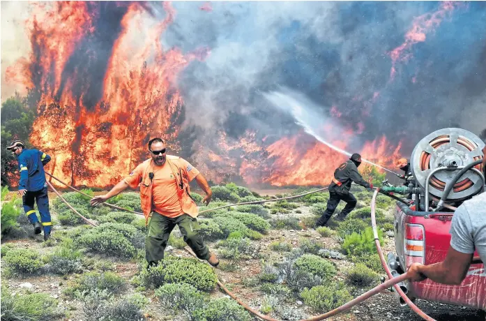  ?? angelos tzortzinis/aFP ?? Los bomberos tratan de extinguir el fuego en Kineta, cerca de Atenas