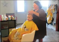  ?? WESTSIDE EAGLE OBSERVER/Susan Holland ?? Hilarie Dodd, owner of the Thairapy hair salon, puts the finishing touches on a haircut for one of her young customers Jan. 9.