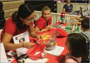  ?? Ryan Mancini/The Signal ?? Safety teachers Stephanie Molt, left, and Michelle Chaney help teach children on how to stay safe at their table for Safety Town at the 15th annual Kids Expo, a fundraiser for the Child &amp; Family Center.