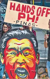  ?? AFP ?? A caricature of China's President Xi Jinping held by an activist during a protest to condemn China's "aggressive actions" in the South China Sea, in Manila, on April 9.