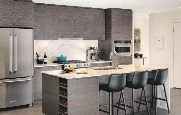  ??  ?? Kitchens feature stainless steel appliances, a large island, flat-panel cabinetry and large-scale quartz topping the counters, as well as providing the solid slab backsplash.