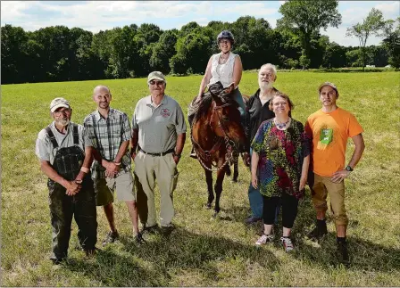  ?? DANA JENSEN/THE DAY ?? From left, members of the Friends of Pachaug Forest Inc., Tom Gaudreau, President Ryan Snide, Vice President Bob Panko, secretary Susan Lane, Alan Cornelius, public informatio­n director Bobbi Cornelius and director of logistics Jesse Gay, pose on the edge of the Button Farm property located off Lee Road in the center of the Pachaug Forest in Griswold on Wednesday. The group is not happy that Gov. Dannel Malloy and the state police want a gun range built on the farm property.