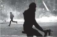  ?? THE ASSOCIATED PRESS ?? A youth runs through a smoke-filled street Monday during a riot as part of the May Day demonstrat­ion in Paris. Police fired tear gas at rowdy protesters on the sidelines of a May Day workers’ march.