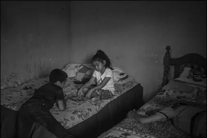  ??  ?? Marelyn Pulex, center, with a cousin, play on a tablet in Santa Rosa de Lima. Marelyn was separated from her mother after the two were caught illegally entering the United States. After 10 weeks apart, they recently were reunited back in Guatemala after being deported from the U.S.