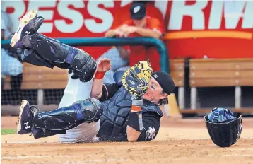  ?? JIM THOMPSON/JOURNAL ?? Isotopes catcher Ryan Hanigan holds on to the baseball after a tumbling catch during Thursday night’s game. Albuquerqu­e defeated El Paso 8-1 at Isotopes Park.