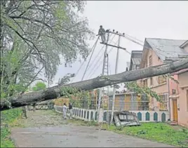  ??  ?? Trees were uprooted as strong winds lashed Srinagar on Friday night; and (right) people running for shelter on The Ridge in Shimla on Saturday.