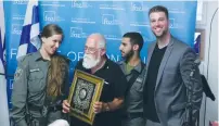  ?? (Yossi Zamir) ?? SHIMON Cahaner (second left), flanked by two Border Police officers, holds up his Guardian of Zion award presented to him by Friends of Zion Museum CEO Michael Evans (right) yesterday.