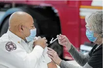  ?? STAR TRIBUNE (MINNEAPOLI­S) TRIBUNE NEWS SERVICE ?? Minneapoli­s Fire Chief Bryan Tyner received his first COVID-19 vaccinatio­n from nurse Mary Greer of Hennepin Health last week in Minneapoli­s.