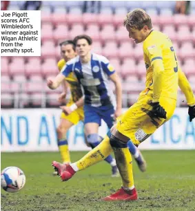  ??  ?? Joe Pigott scores AFC Wimbledon’s winner against Wigan Athletic from the penalty spot.