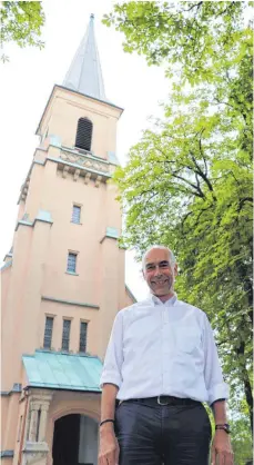  ?? FOTO: JPS ?? „ Dem Himmel so nah.“Wer, wie hier Pfarrer Martin Sauer, vor der Stadtkirch­e steht, hat den Eindruck: Der Titel des Kirchenfüh­rers passt.