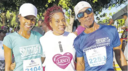  ??  ?? LASCO Distributo­rs Brand Manager Renee Rose (centre) congratula­tes the top 5K walkers (from left) first-place female Anna-kay Swaby of Shizzle Fit and first-place male Lenworth Hunter at the first staging of the Civil Service Week 5K at Emancipati­on Park last month.