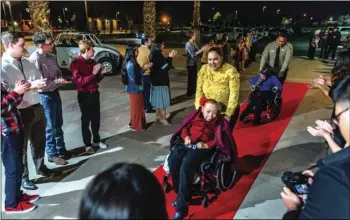  ?? PHOTO VINCENT OSUNA ?? Irma Torres (middle) receives the red-carpet treatment as she and other guests are escorted into the second annual Night to Shine event held Friday night at Imperial Valley College in Imperial.