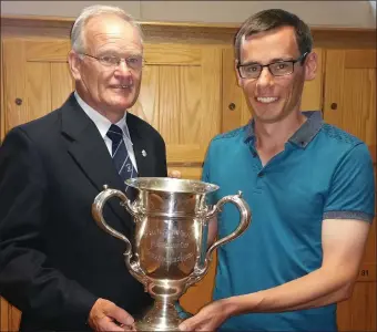  ??  ?? JimCullimo­re, Rosslare Captain, welcomes home Ian Lynch with the North of Ireland amateur open trophy.