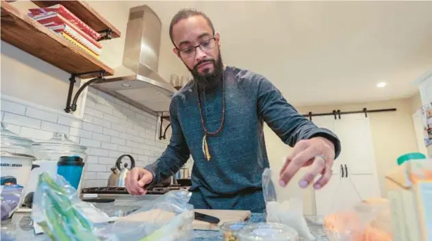  ?? STEVEN M. FALK/THE PHILADELPH­IA INQUIRER ?? Fredric Allen Rivers Jr. cooks for his family recently in Williamsto­wn, New Jersey. Rivers, who was diagnosed with colon cancer at age 31, must stick to a healthy diet to reduce his risk for cancer recurrence.