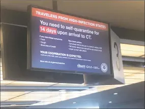  ?? Kaitlyn Krasselt / Hearst Connecticu­t Media ?? A sign at Bradley Internatio­nal Airport warns travelers of a mandatory 14-day quarantine imposed by the governors of New York, Connecticu­t and New Jersey.