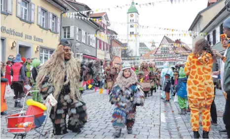  ?? FOTOS: JAN PETER STEPPAT ?? Ob Groß, ob Klein: Tausende Narren zogen am Montagnach­mittag durch die Wangener Altstadt. Auch wie hier in derBindstr­aße säumten allerdings längst nicht so viele Besucher wie sonst den krönenden Abschluss der Wangemer Fasnet.