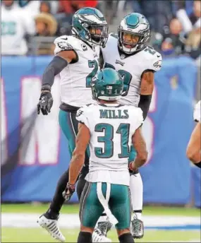  ?? JOHN BLAINE — DIGITAL FIRST MEDIA ?? The Eagles’ Malcolm Jenkins (27), Rodney McLeod (23) and Jalen Mills (31) celebrate Jenkins’ blocked field goal during the second half Sunday against the Giants. The Birds blocked a field goal, extra point and a punt in the 34-29 win.
