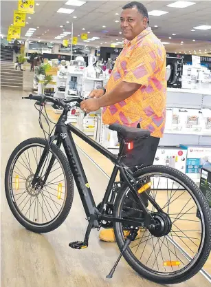  ?? Picture: ANASEINI DIMATE ?? Courts Mega Samabula staff Maikeli Narara showcases the new E-Bicycle.