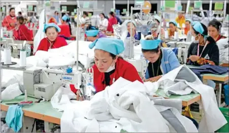  ?? YOUSOS APDOULRASH­IM ?? Garment workers at their sewing machines at a factory in Kandal province’s Ang Snuol district on January 20.