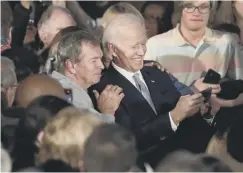  ??  ?? 0 Mr Biden takes a selfie with supporters in South Carolina