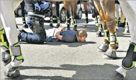  ?? AFP ?? Police detain an anti-lockdown protester in Melbourne during a rally on Sunday. Defying stay-at-home orders, the crowd gathered at the central Queen Victoria market where they were met by a heavy police presence. Melbourne continues to enforce strict lockdown measures to battle a second wave of the Covid-19 pandemic.