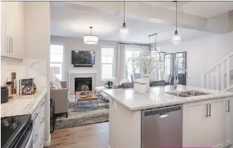  ?? PHOTOS: CALBRIDGE HOMES ?? The kitchen in the Colorado duplex features an island and extended eating bar, along with stainless steel appliances.