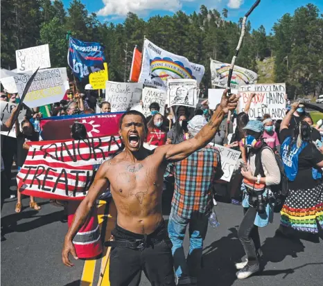  ?? Picture: AFP ?? PROTESTS: Activists make a stand at the Mount Rushmore National Monument during President Trump’s visit.