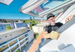 ?? ?? Zimmermeis­ter Eugen Penner schaut aus einem der Dachfenste­r heraus – ein fantastisc­her Blick auf Bielefeld bietet sich hier. Die Arbeit hat sich gelohnt, findet nicht nur er.