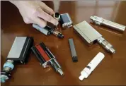  ?? STEVEN SENNE — THE ASSOCIATED PRESS FILE ?? Marshfield High School Principal Robert Keuther displays vaping devices that were confiscate­d from students in such places as restrooms or hallways at the school in Marshfield, Mass.