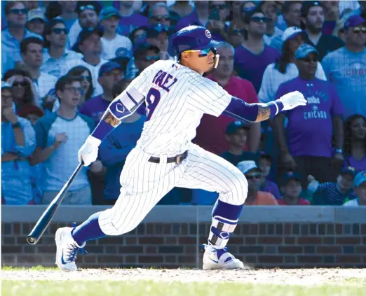  ?? DAVID BANKS/ AP ?? Javy Baez drives in the tying run in the eighth inning with an infield single on a comebacker that Reds reliever Jared Hughes couldn’t handle.