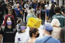  ?? MATT DUNHAM/AP ?? People walk with bags after shopping at the Selfridges department store in London, Monday. Shops reopened across England for the first time since the country went into lockdown in March.