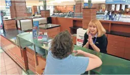  ?? MICHAEL CHOW/THE REPUBLIC ?? Mary Jo West helps Donna Rapp while working at the informatio­n desk at Phoenix Shy Harbor Airport on April 3.