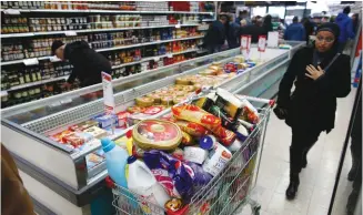  ?? (Ronen Zvulun/Reuters) ?? An overflowin­g grocery cart in a Jerusalem supermarke­t. Shouls unhealthy products be labeled?