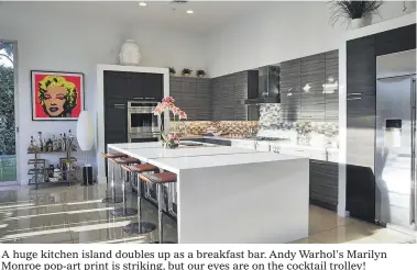  ??  ?? A huge kitchen island doubles up as a breakfast bar. Andy Warhol’s Marilyn Monroe pop-art print is striking, but our eyes are on the cocktail trolley!