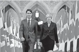  ?? [AP PHOTO] ?? Prime Minister Justin Trudeau and British Prime Minister Theresa May walk Monday through the Hall of Honour on Parliament Hill in Ottawa, Ontario, Canada.