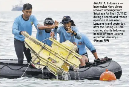  ?? (Photos: AFP) ?? JAKARTA, Indonesia — Indonesian Navy divers recover wreckage from Sriwijaya Air flight SJY182 during a search and rescue operation at sea near Lancang Island yesterday, after the Boeing 737-500 crashed shortly following its take off from Jakarta airport on January 9.