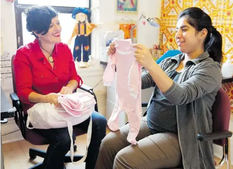  ??  ?? Social worker Anne Van Den Bosschelle helps expectant mother Marriam Naseeb decide on baby clothes at La Maison Bleue in Park-Extension.