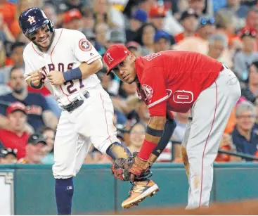  ?? Yi-Chin Lee photos / Houston Chronicle ?? Angels third baseman Yunel Escobar, right, doesn’t want to give up on the safe call as he playfully lifts the leg of the Astros’ Jose Altuve at third. Altuve went 2-for-3 to raise his average to .324 on Saturday.