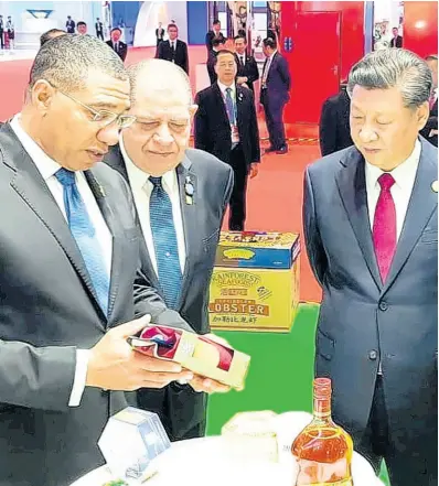  ?? FILE ?? Prime Minister Andrew Holness (left) speaks about the Jamaican products on display at China Internatio­nal Import Expo in Shanghai to President of China Xi Jinping on November 5, 2019. Industry Minister Audley Shaw is at centre.