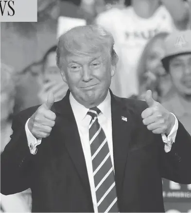  ?? RALPH FRESO / GETTY IMAGES ?? U.S. President Donald Trump gives a thumbs up to supporters at the Phoenix Convention Center during a rally Tuesday night, where he threatened to end NAFTA, and to shut down the government if a wall with Mexico isn’t built.