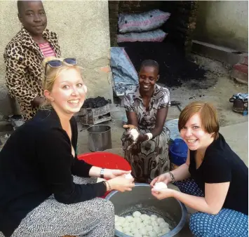  ?? Foto: privat ?? Julia Hartmann (links) und Alice Wagner im Kreise ihrer „neuen“Familie in Tansania. Was aussieht wie Knödelteig, wird zu Brot. Gebacken auf Steinen am Feuer ist es tägliche Nahrung für die Bewohner des „Olive Branch for Children’“.