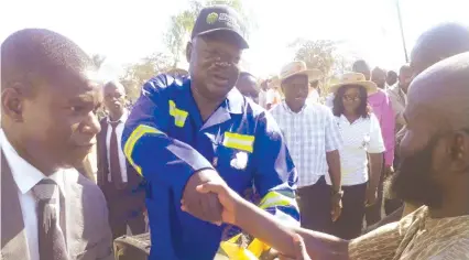  ??  ?? Minister Shiri (in blue work suit) hands over maize seed to a farmer in Mutoko last week