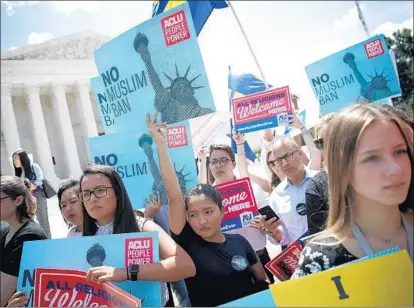  ?? Win McNamee Getty Images ?? PROTESTERS gathered Tuesday outside the Supreme Court, where justices upheld President Trump’s travel ban, 5 to 4.