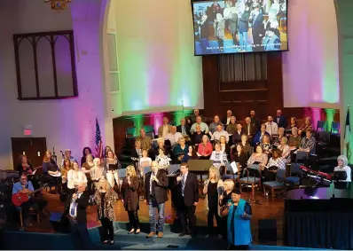  ?? (Photo by Neil Abeles) ?? Atlanta First Baptist Church fills its choir loft to overflow as it sings with piano, organ, stringed instrument­s and drums. Special lighting and a large screen that easily shows the words to be sung are also a part of the worship experience.