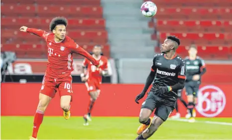  ?? FOTO: BERND THISSEN/DPA ?? Solche Szenen hatte er (zu) selten: Bayerns Leroy Sané (li.) legt den Ball mit dem Kopf an Leverkusen­s Edmond Tapsoba vorbei.