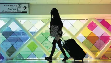  ?? DANIEL A. VARELA dvarela@miamiheral­d.com ?? A traveler walks through Miami Internatio­nal Airport on Nov. 23, 2021.